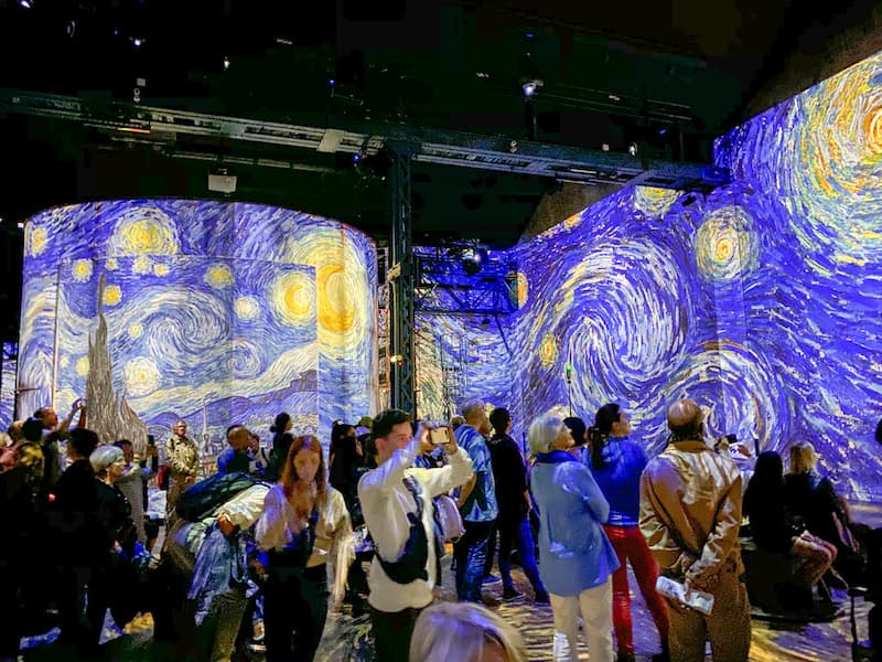 People enjoying the Van Gogh art presentation at Atelier des Lumieres in Paris.