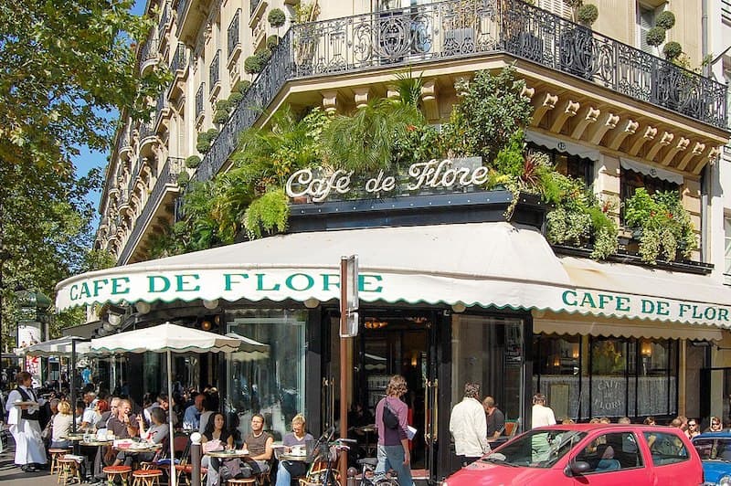 Cafe de Flore restaurant exterior with people sitting at tables on the terrace.