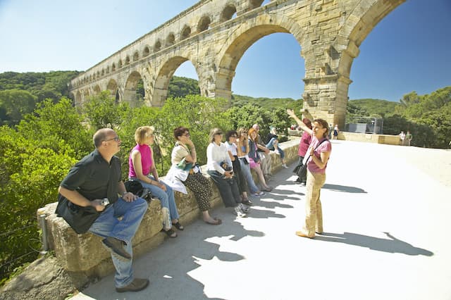 Tour guide speaking to tour group at Pont du Gard in France.