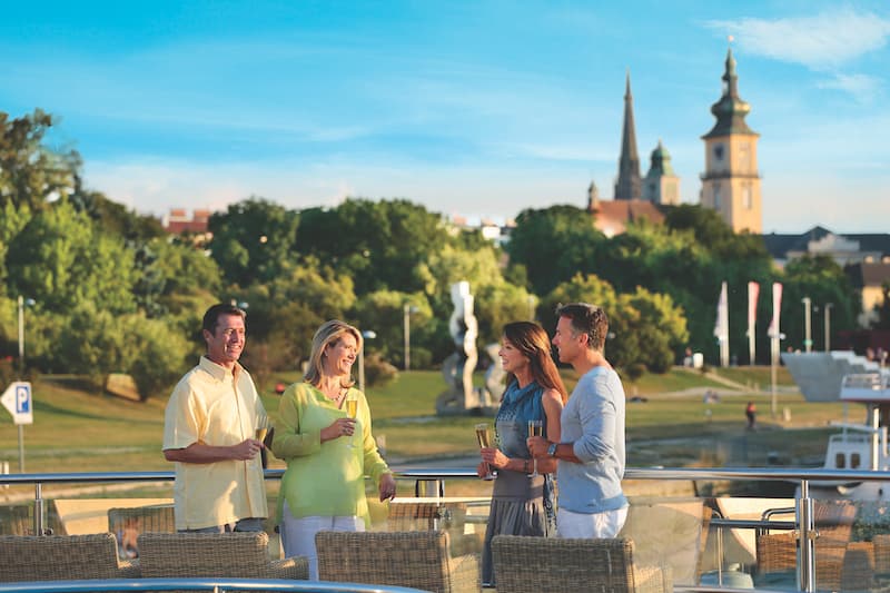 Two couples having champagne on the top deck of their European river cruise ship