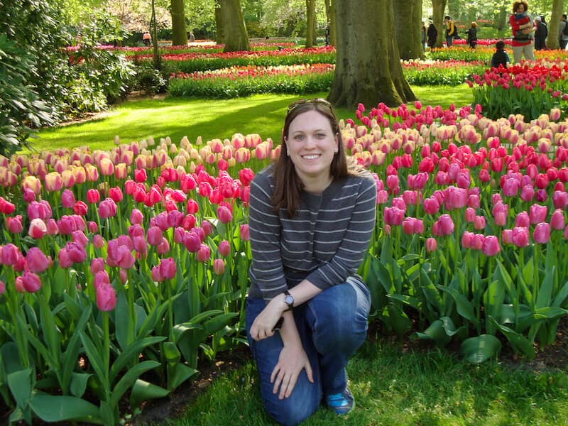 Cassie Tetro sitting in front of a row of tulips at Keukenhof Gardens