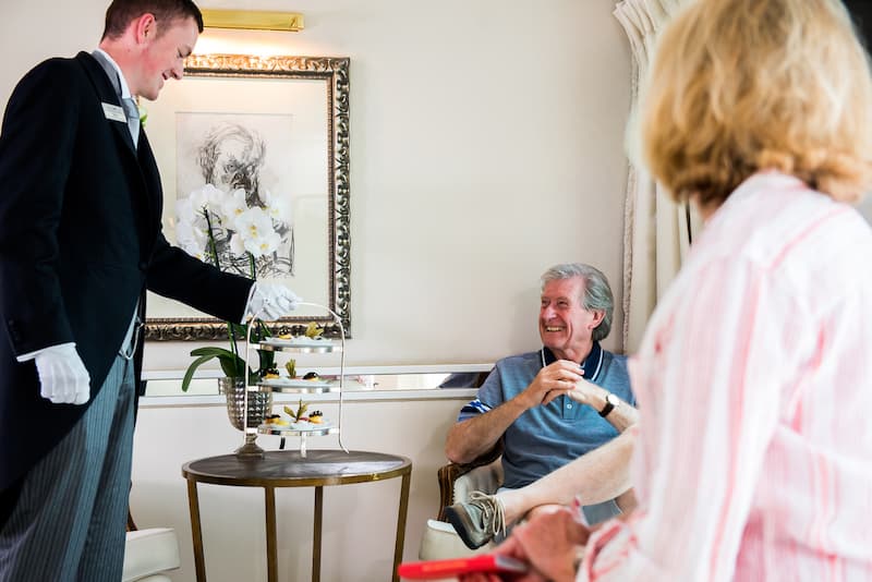 Uniworld river cruises butler serving afternoon tea to a guest on the ship
