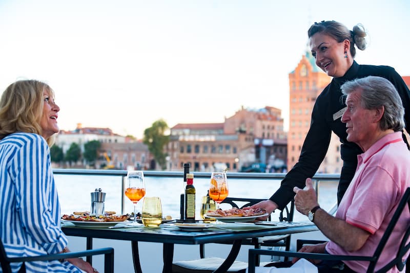Two people having their dinner on the deck of a Uniworld river cruise ship