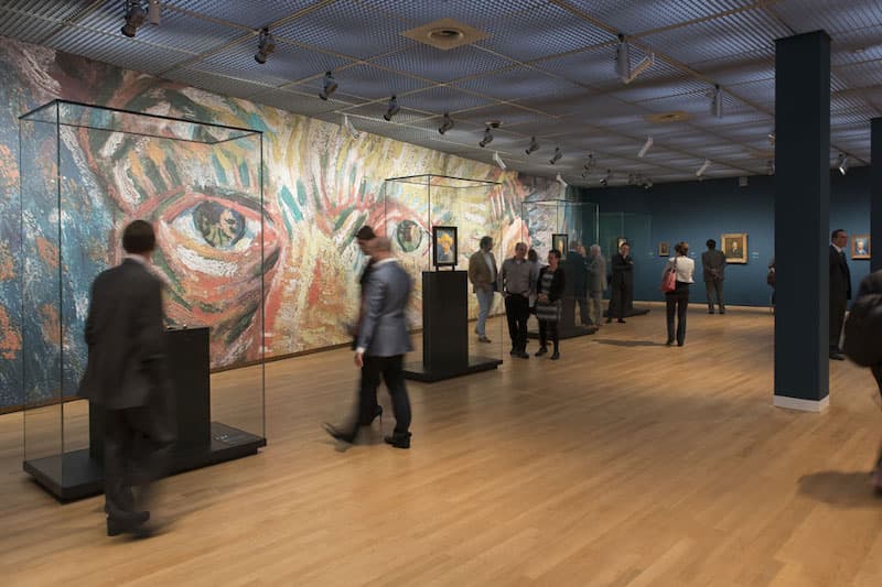 People walking around the Self-Portrait Gallery at the Van Gogh Museum in Amsterdam