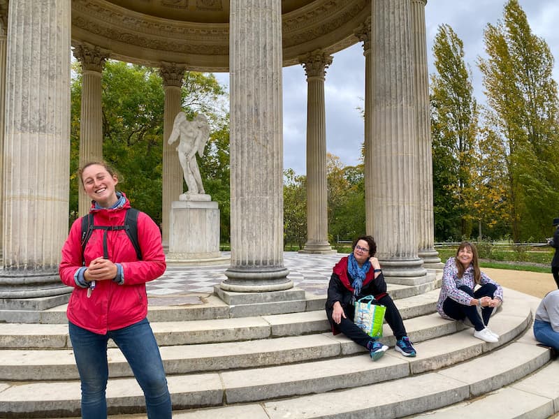 Sightseeing tour group in front of the cupid statue on the grounds of Versailles
