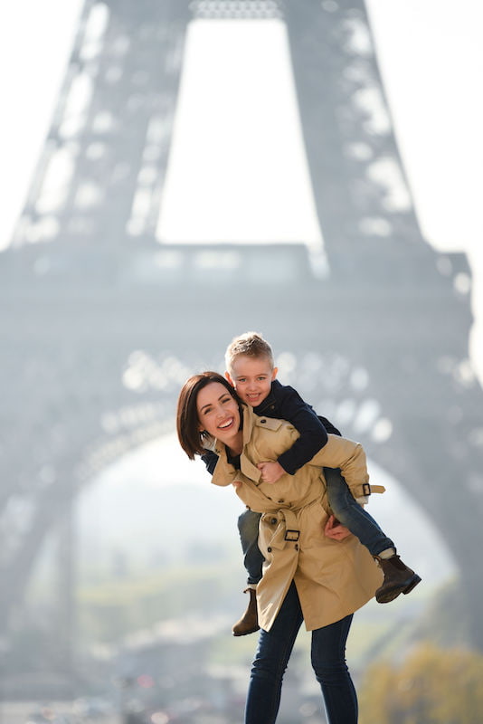 Mother and son posing for a photo in front of the Eiffel Tower