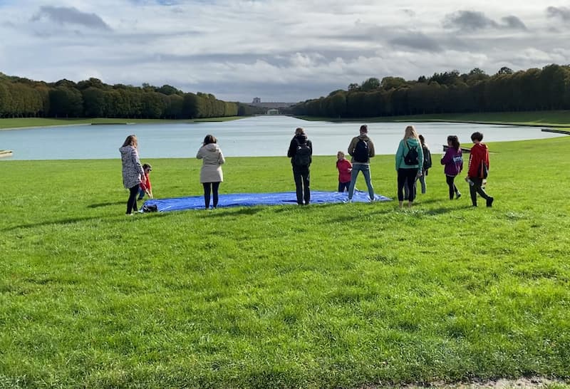 Bike tour group setting up a picnic with a view of the Palace of Versailles