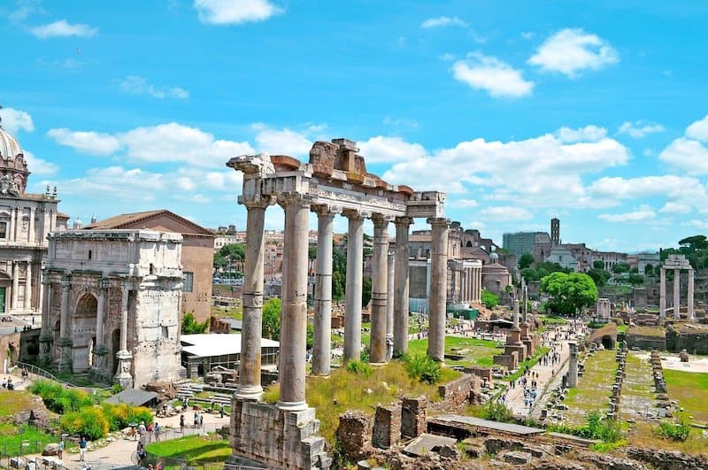 People walking around the ruins of the Roman Forum in Rome, Italy.